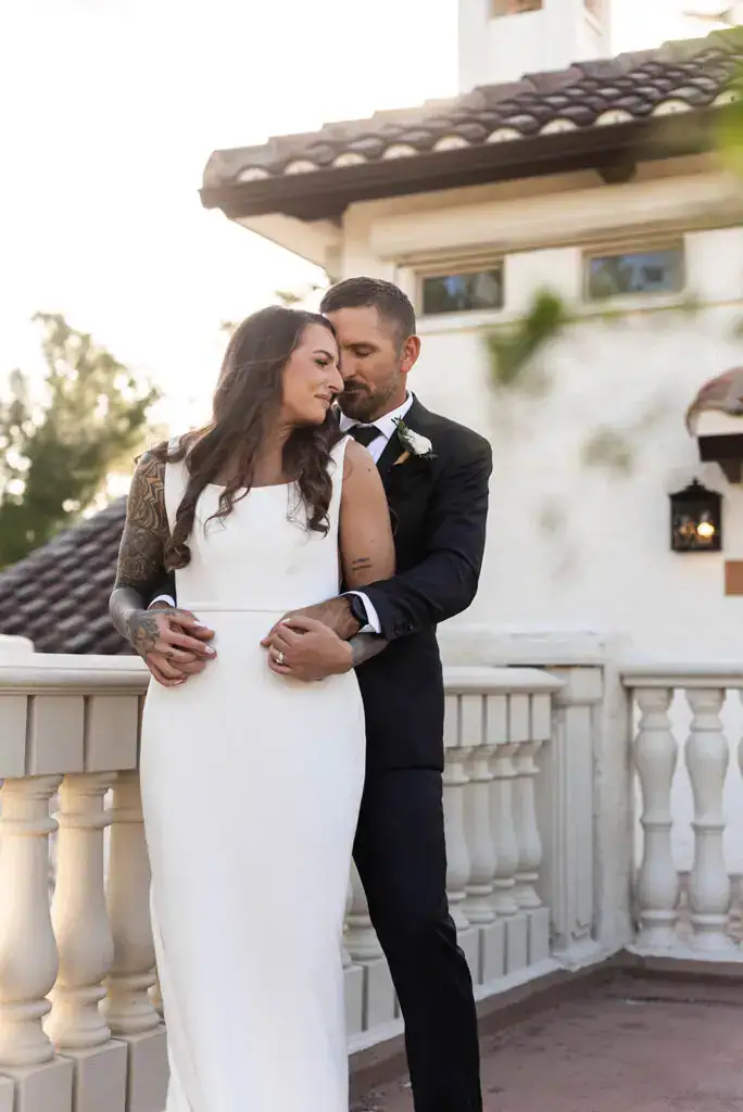 Kerry and Tucker share an intimate moment on the Tuscan-style balcony at Bonita Ranch, surrounded by Mediterranean charm and lush greenery. Wedding Venue in Brevard County, Melbourne, Florida.