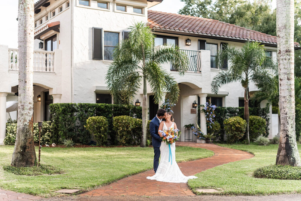 Couple in wedding attire standing in front of the Mediterranean villa at Bonita Ranch in Melbourne, Florida — one of the best places to get married in Florida.