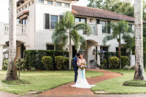 Couple in wedding attire standing in front of the Mediterranean villa at Bonita Ranch in Melbourne, Florida — one of the best places to get married in Florida.