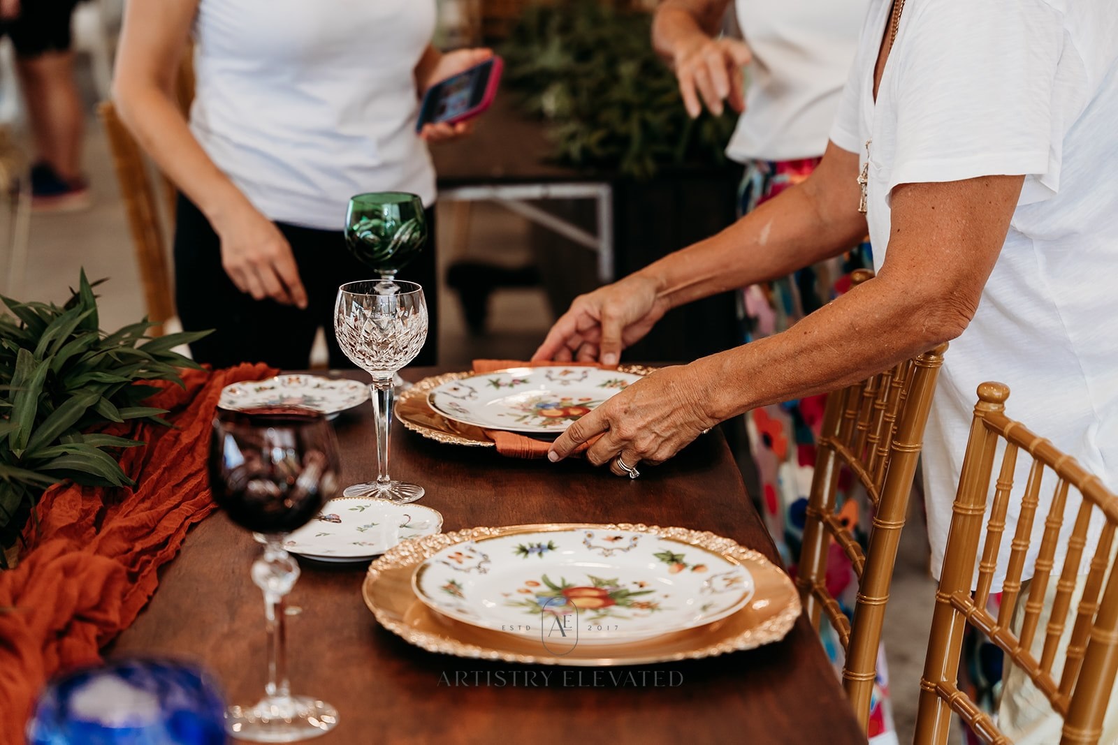 Vendor setting up reception tables with Bonita Ranch nursery plants and table runners in Melbourne Florida wedding venue