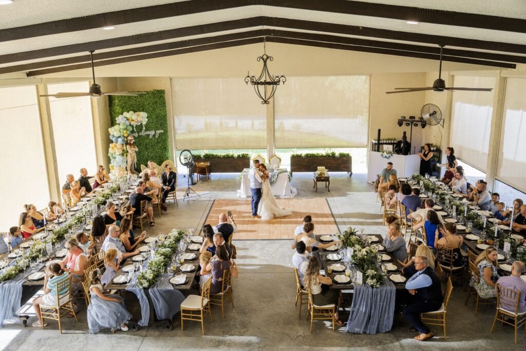 Wooden Italian long tables with plant nursery greenery decor at Bonita Ranch agritourism wedding venue in Brevard County Florida