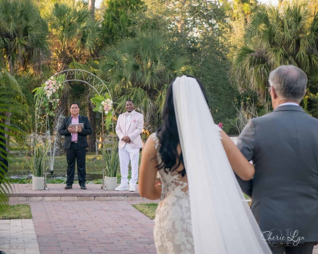 Bride walking down aisle for intimate garden elopement ceremony at Bonita Ranch Melbourne Florida