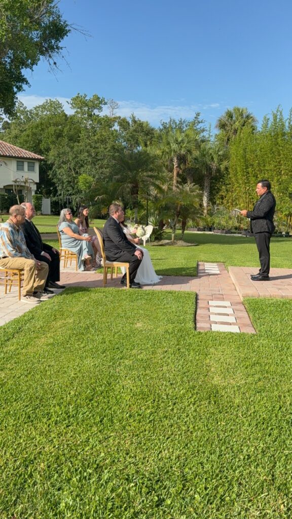 Intimate outdoor elopement ceremony at Bonita Ranch Mediterranean wedding venue in Melbourne Florida with bride, groom, officiant, and family witnesses.