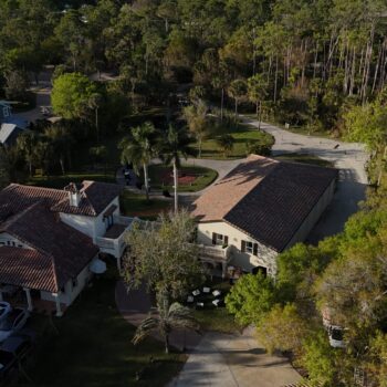 Aerial view of Bonita Ranch wedding venue in Melbourne, Florida, showcasing the back courtyard and portico surrounded by lush greenery.