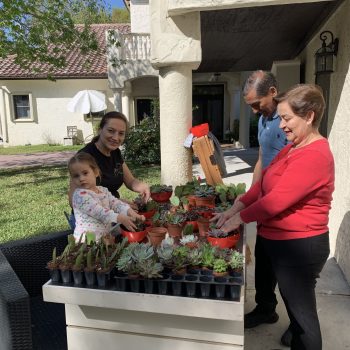 Customer smiling while holding a tray of assorted succulents at Bonita Ranch Nursery in Melbourne, Florida.