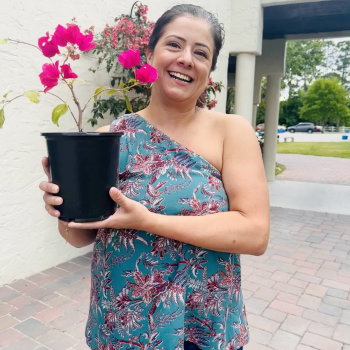 Happy customer holding vibrant pink bougainvillea at Bonita Ranch Nursery in Melbourne, Florida.